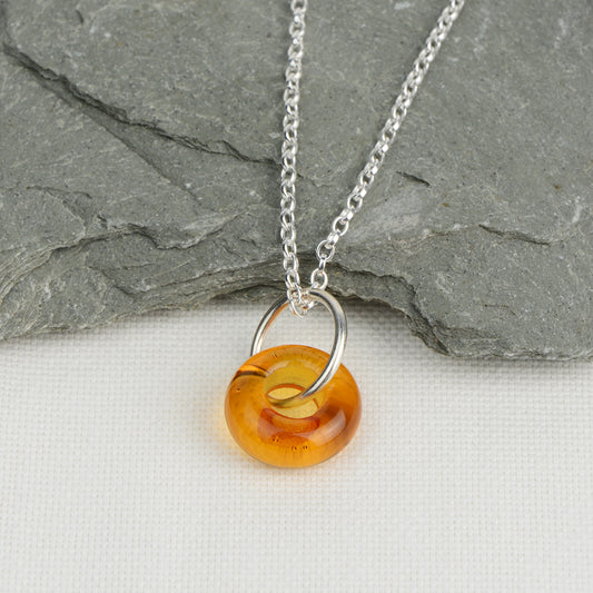 Doughnut shaped amber glass bead on silver chain