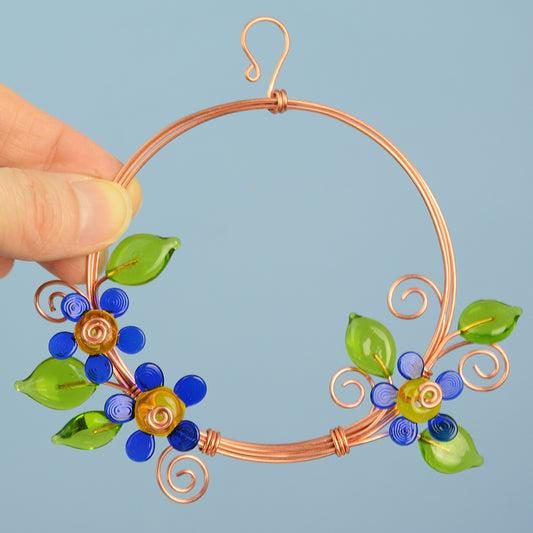 Miniature copper wreath with blue glass flowers and green glass leaves
