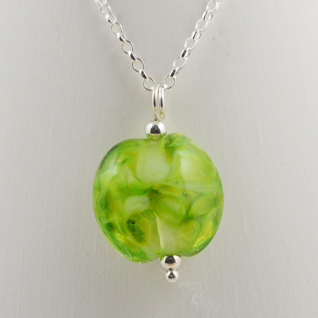 Shades of green lentil shaped glass bead pendant on silver chain