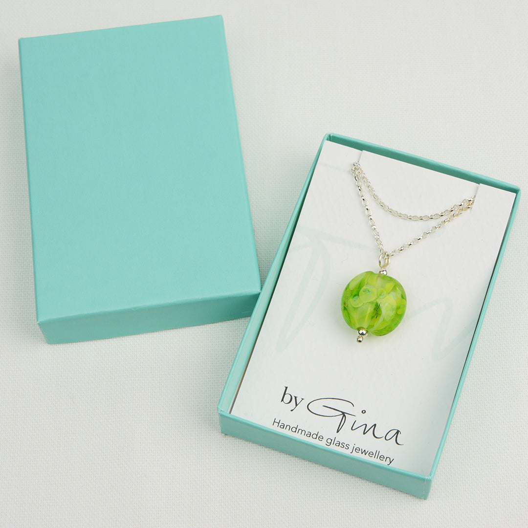Shades of green lentil shaped glass bead pendant on silver chain in turquoise gift box