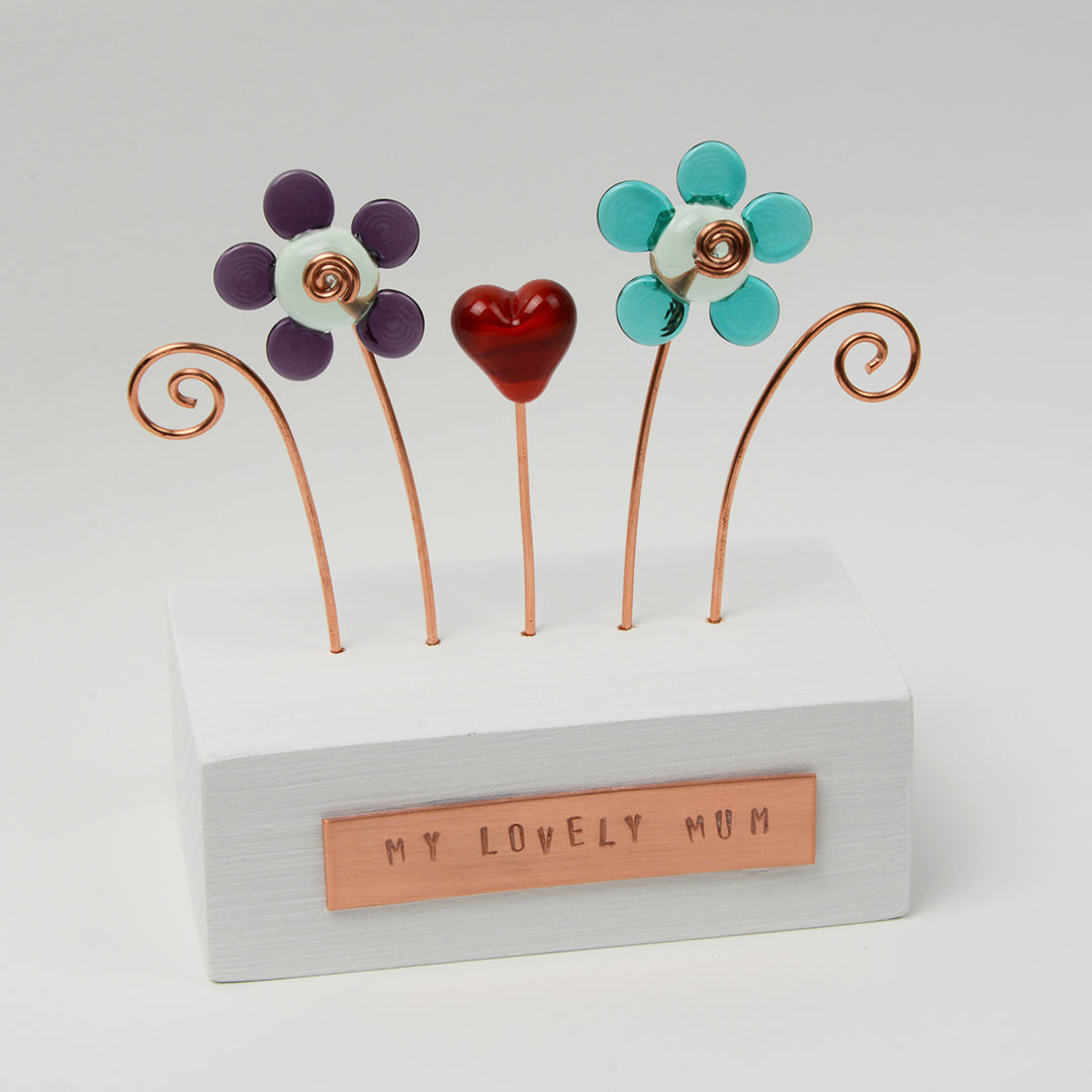 Wooden block with two glass flowers and a heart with copper plaque reading my lovely mum