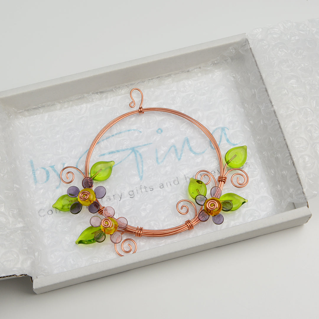 Miniature copper wreath with purple glass flowers and green glass leaves in white gift box