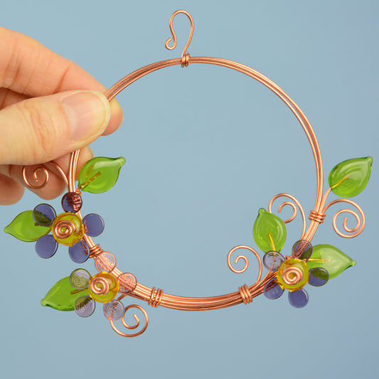 Miniature copper wreath with purple glass flowers and green glass leaves
