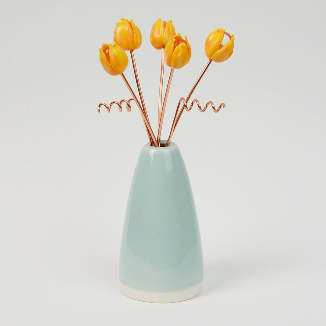 Miniature pale teal porcelain cone vase with yellow glass tulips