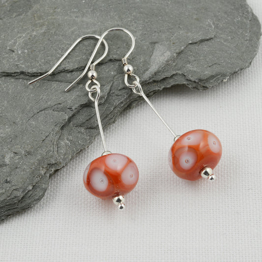 Coral glass beads with white glass details and trapped air bubbles on silver drop earrings