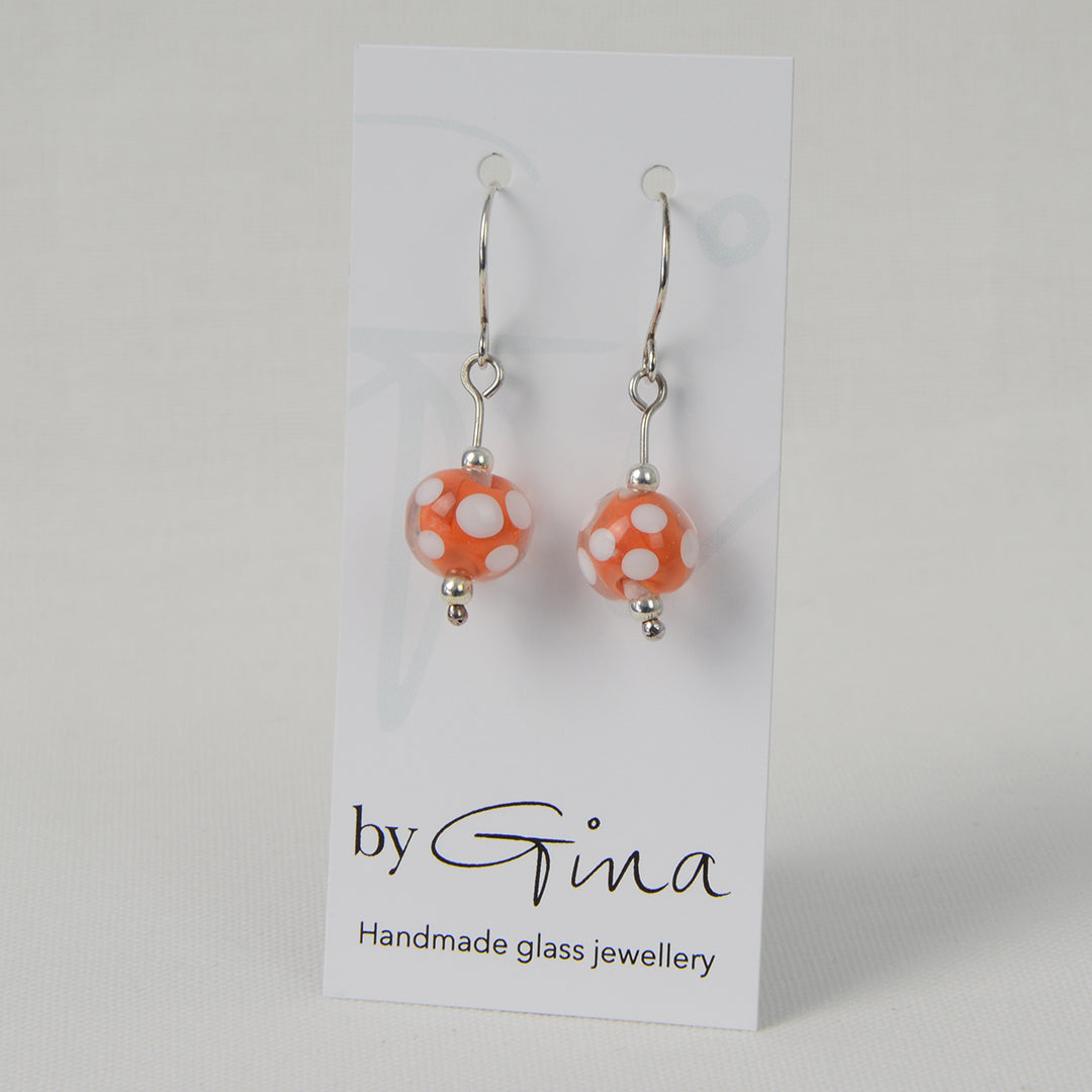 Encased orange and white spotty glass bead earrings