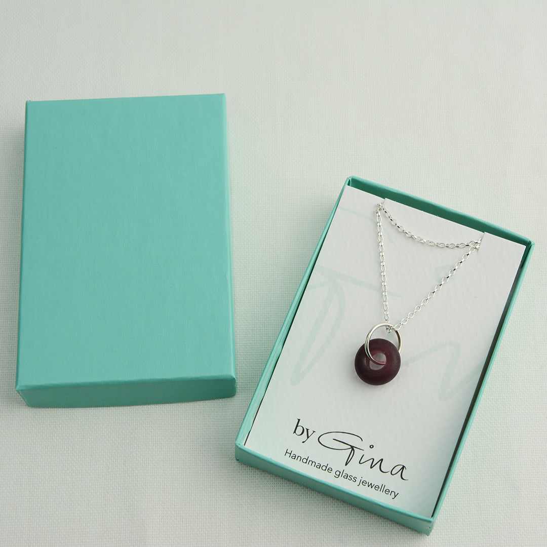 Etched purple glass doughnut shaped bead pendant on silver chain in turquoise gift box