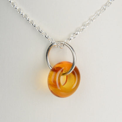 Doughnut shaped amber glass bead on silver chain