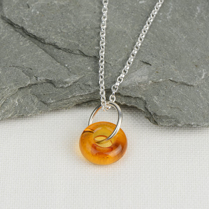 Doughnut shaped amber glass bead on silver chain