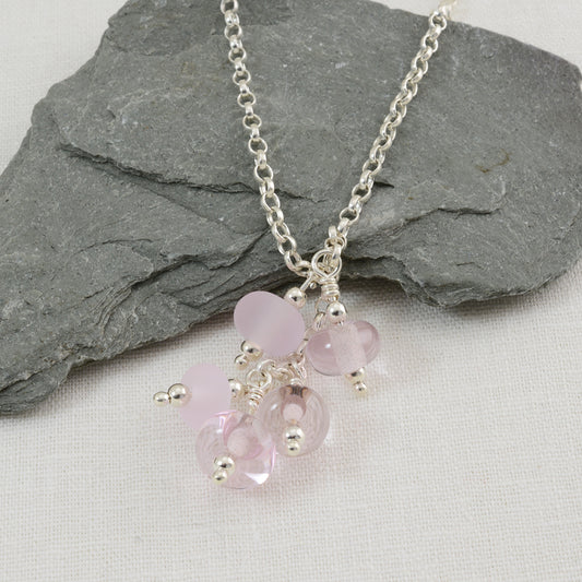 Cluster of pink glass beads. some etched some shiny on chunky silver chain