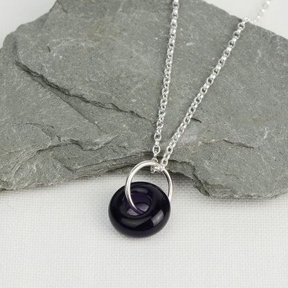 Deep purple glass doughnut shaped bead pendant on silver chain