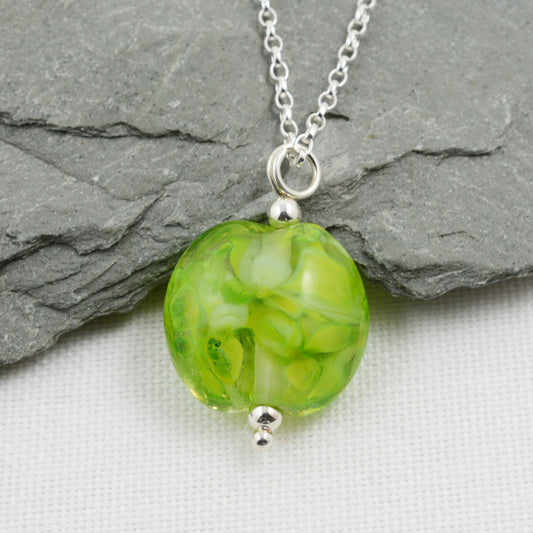 Shades of green lentil shaped glass bead pendant on silver chain