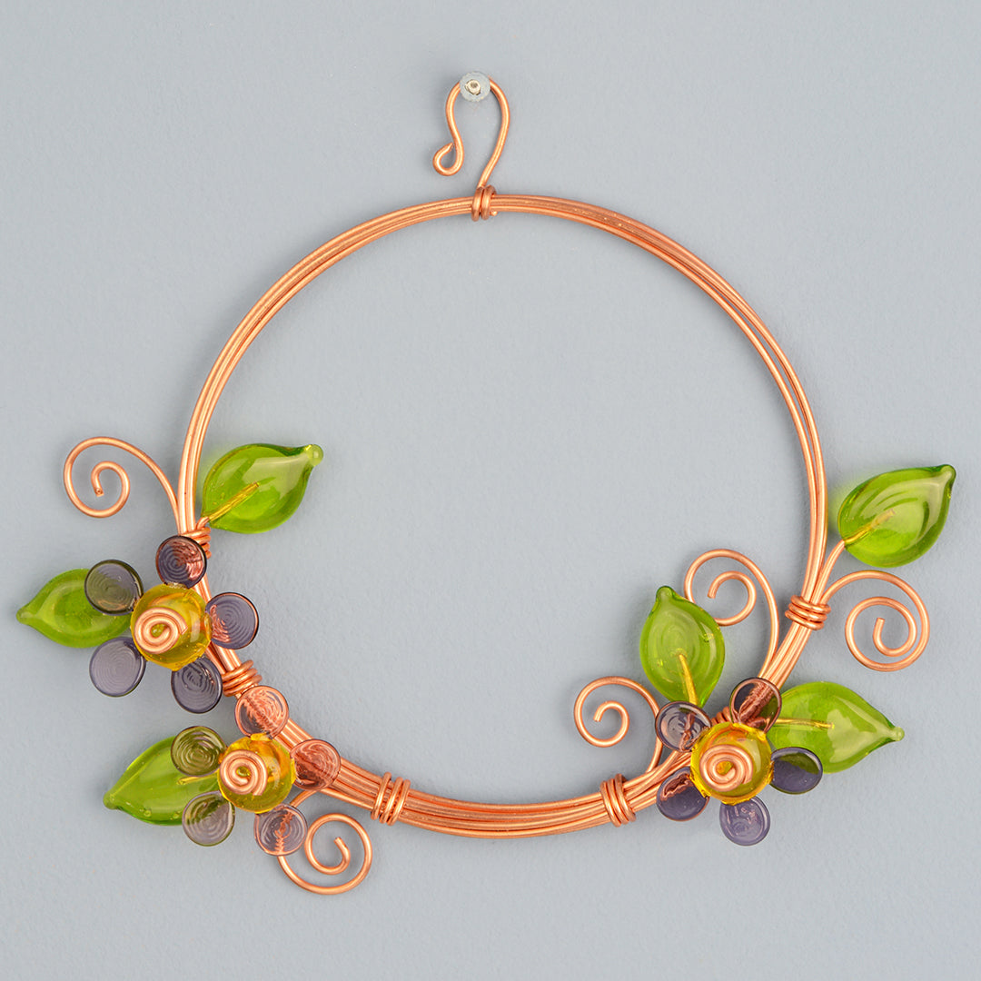 Miniature copper wreath with purple glass flowers and green glass leaves