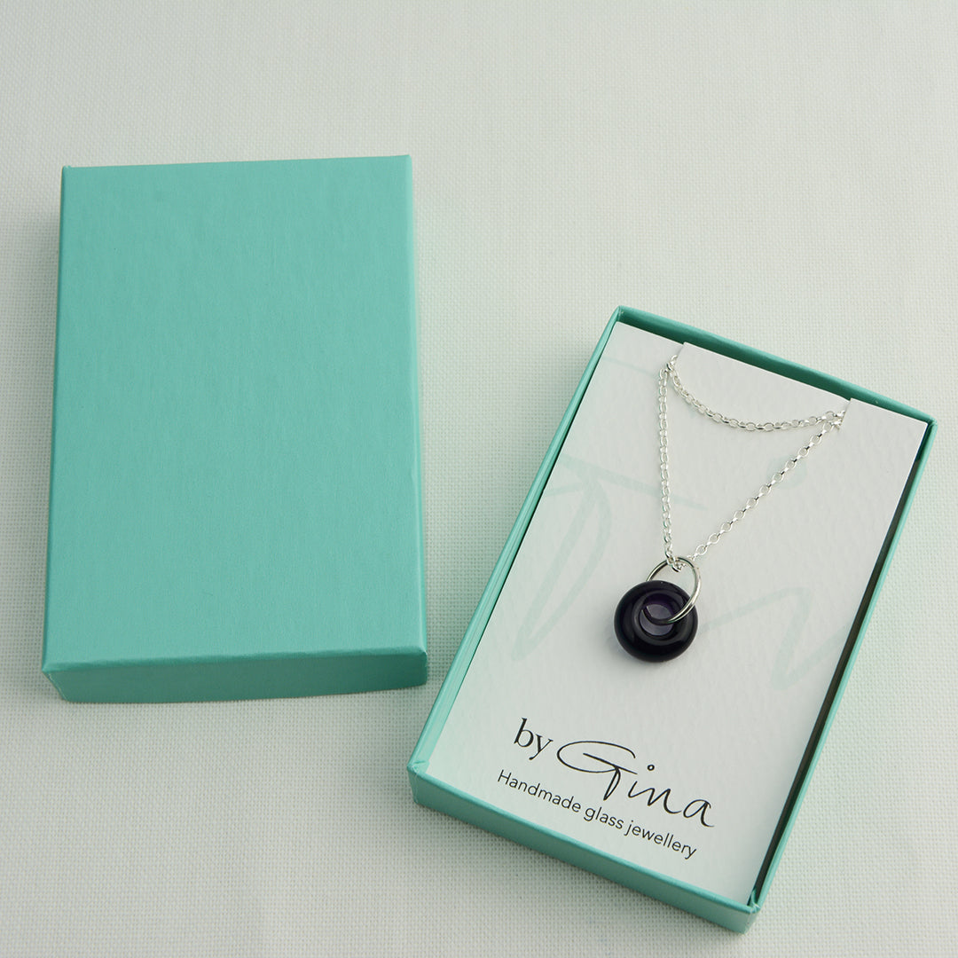 Deep purple glass doughnut shaped bead pendant on silver chain in turquoise gift box
