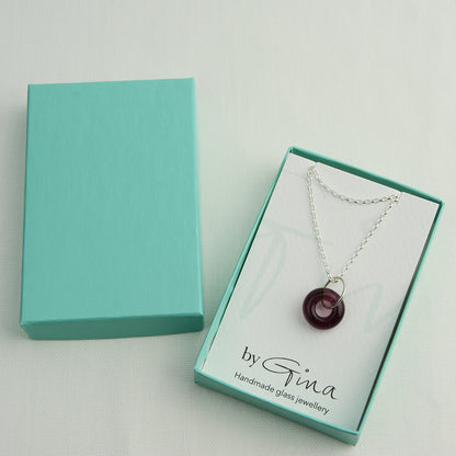 Doughnut shaped plum coloured glass bead on silver chain in turquoise gift box