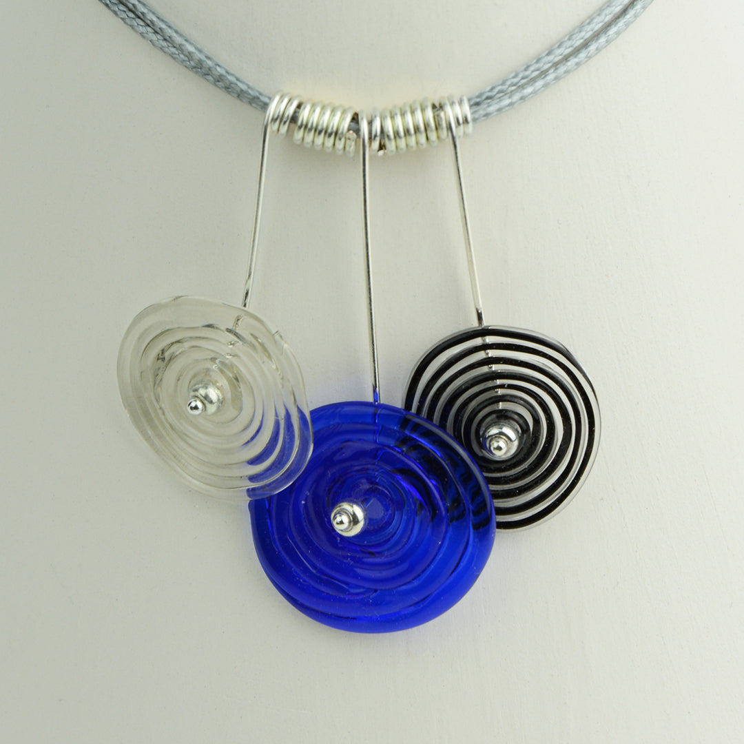 Three spiral beads in grey, blue and black inline on silver headpin drops with silver spiral spacers on grey necklace cord