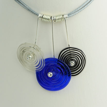 Three spiral beads in grey, blue and black inline on silver headpin drops with silver spiral spacers on grey necklace cord