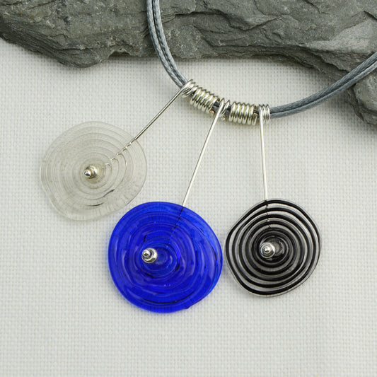 Three spiral beads in grey, blue and black inline on silver headpin drops with silver spiral spacers on grey necklace cord